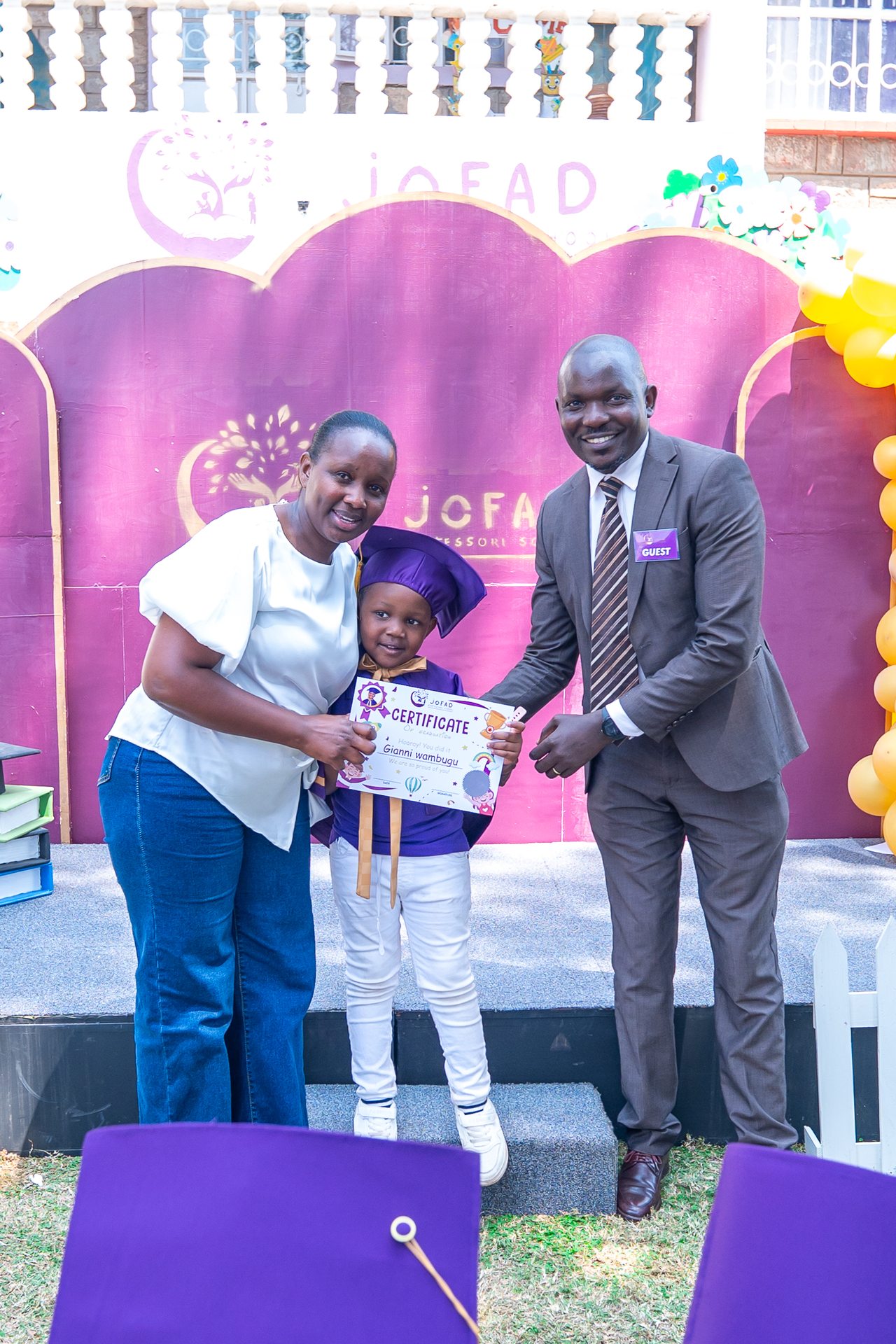 A Jofad graduate with their proud family holding a graduation certificate