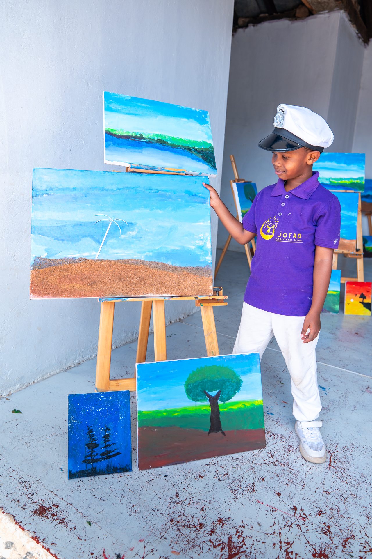 Student proudly showing his paintings
